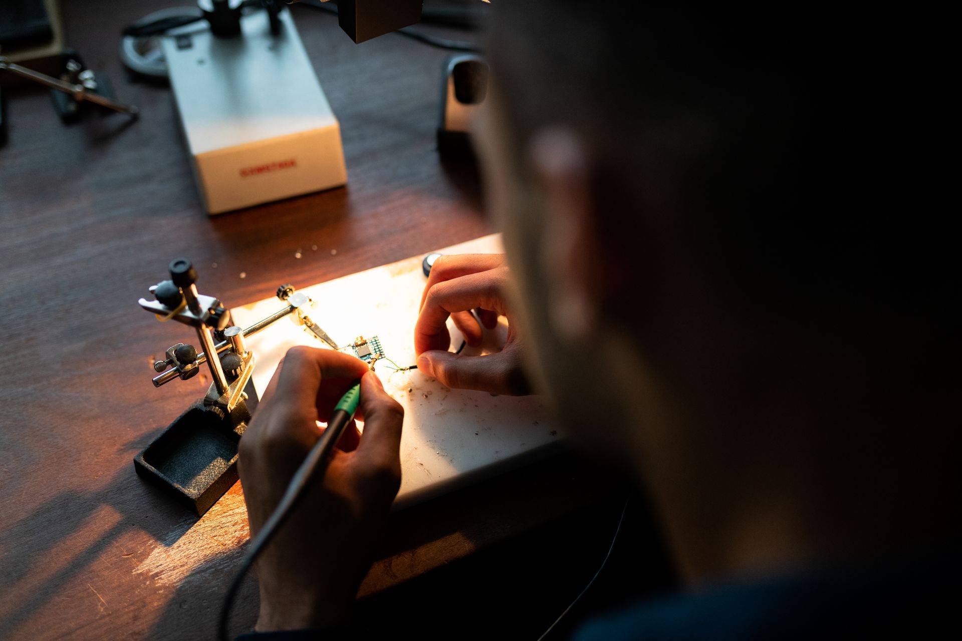 Ruky spájkujú vlastný elektronický obvod pri lampe